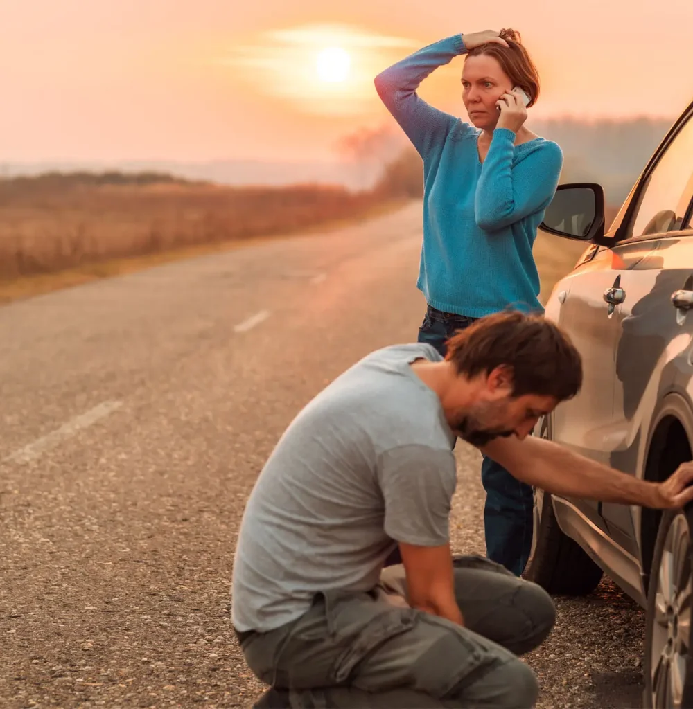 Couple stranded with their vehicle in the middle of the day on the side of the highway.